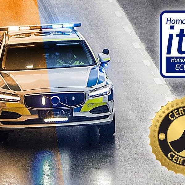 Coche policial con puente de luces LED ámbar y azul en carretera mojada, homologado ITV ECE R65