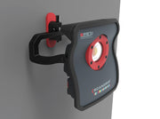 Luz de trabajo LED Scangrip SPS 7 montada en pared con soporte articulado rojo y negro