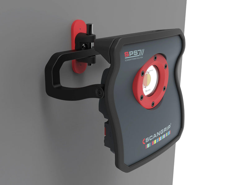 Luz de trabajo LED Scangrip SPS 7 montada en pared con soporte articulado rojo y negro